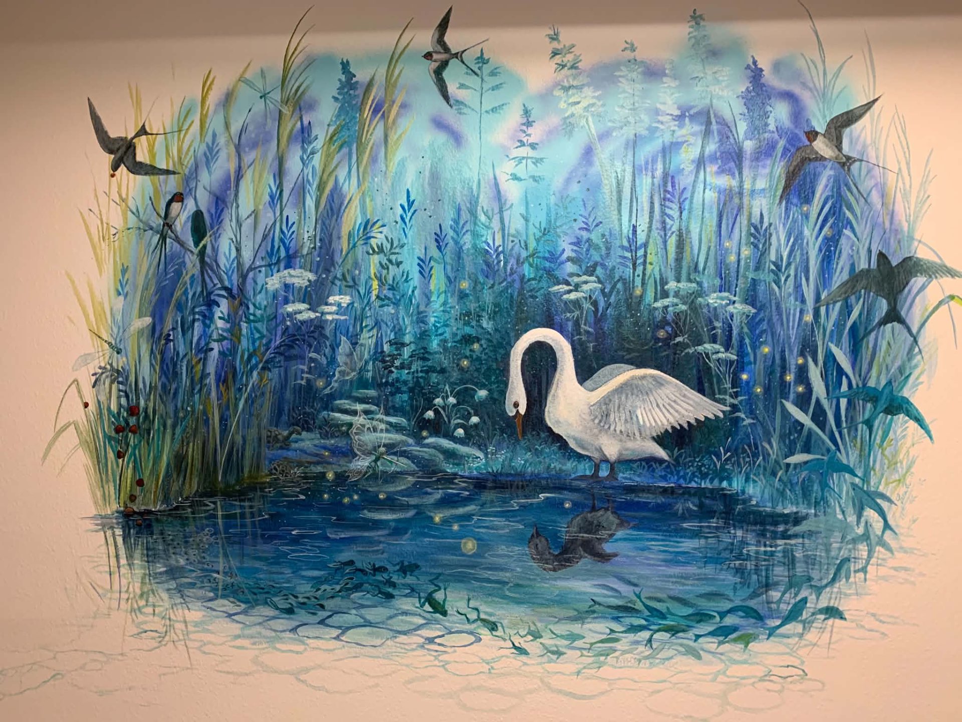 Maleri af en hvid svane ved blåt vand, omgivet af siv, blomster og svaler